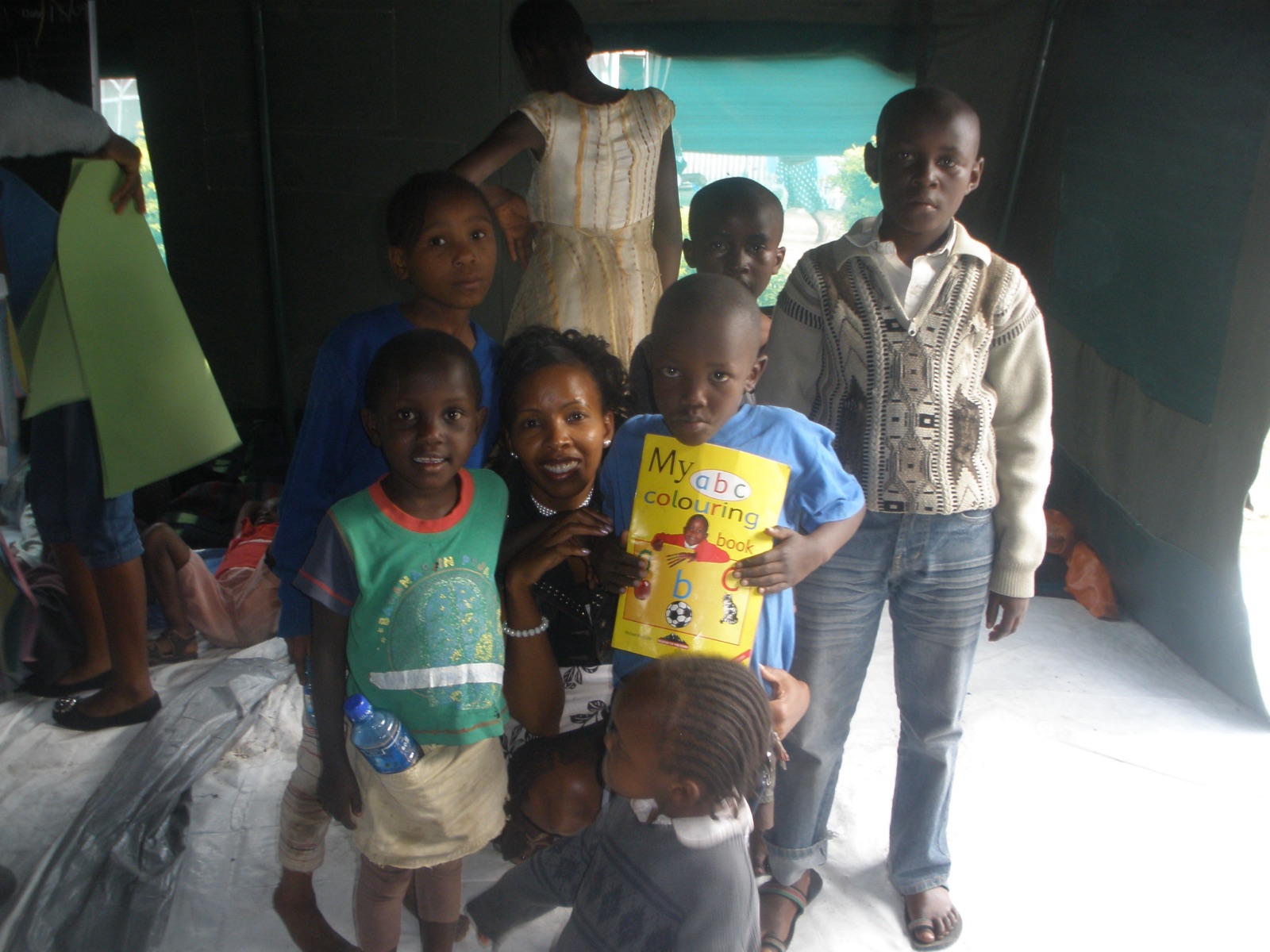 Nduta Angels Foundation founder with children holding a colouring book